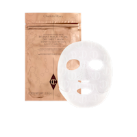 A dry sheet mask in textured fabric along with its golden-coloured foil packaging behind it. 