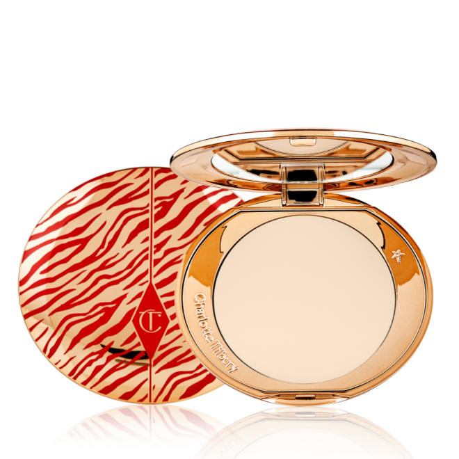 An open, pressed powder compact for fair skin tones with a mirrored lid, in gold-coloured packaging with red-coloured tiger stripes on the lid.