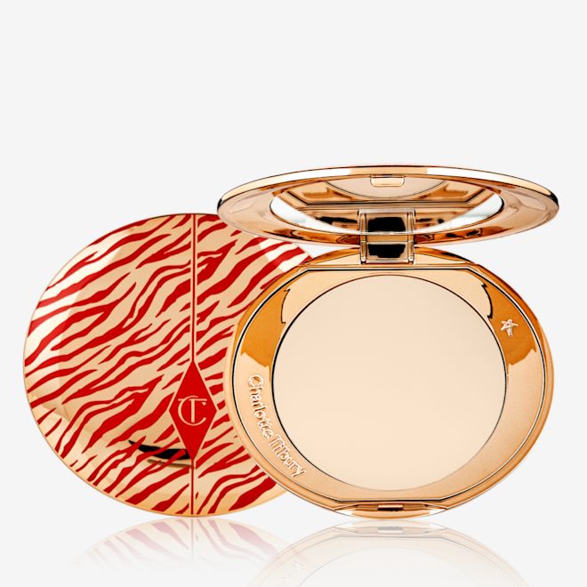 Airbrush Flawless Finish Powder in Fair Lunar New year open An open, pressed powder compact for fair skin tones with a mirrored lid, in gold-coloured packaging with red-coloured tiger stripes on the lid.