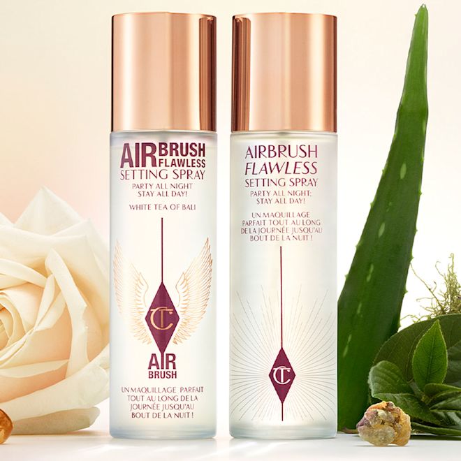Airbrush Flawless Setting Spray scented and scent-free Two setting sprays in clear bottles with gold-coloured lids, one scent-free and the other scented.