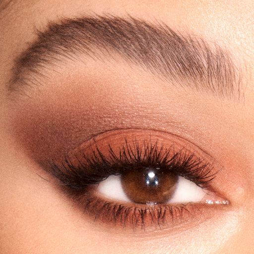 Eye close-up of a fair-toned, brown-eyed model wearing a smokey, brown eye shadow.