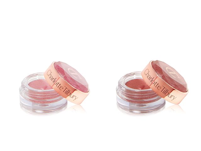 Two, open shimmery cream eyeshadows in a berry-pink shade and rose gold shade in glass pots with their lids next to them.