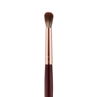 Close-up of an eyeshadow blending brush with soft bristles and a rose-gold and dark crimson handle. 