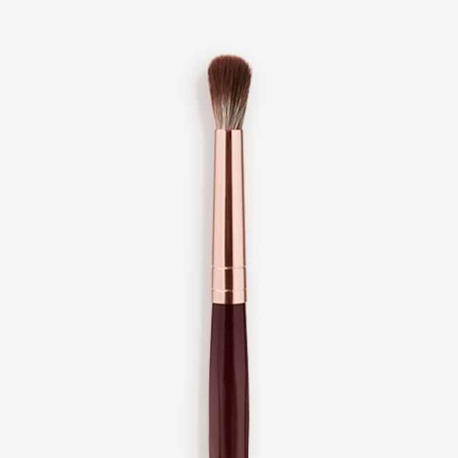 Synthetic Eye Blender Brush close-up Close-up of an eyeshadow blending brush with soft bristles and a rose-gold and dark crimson handle.