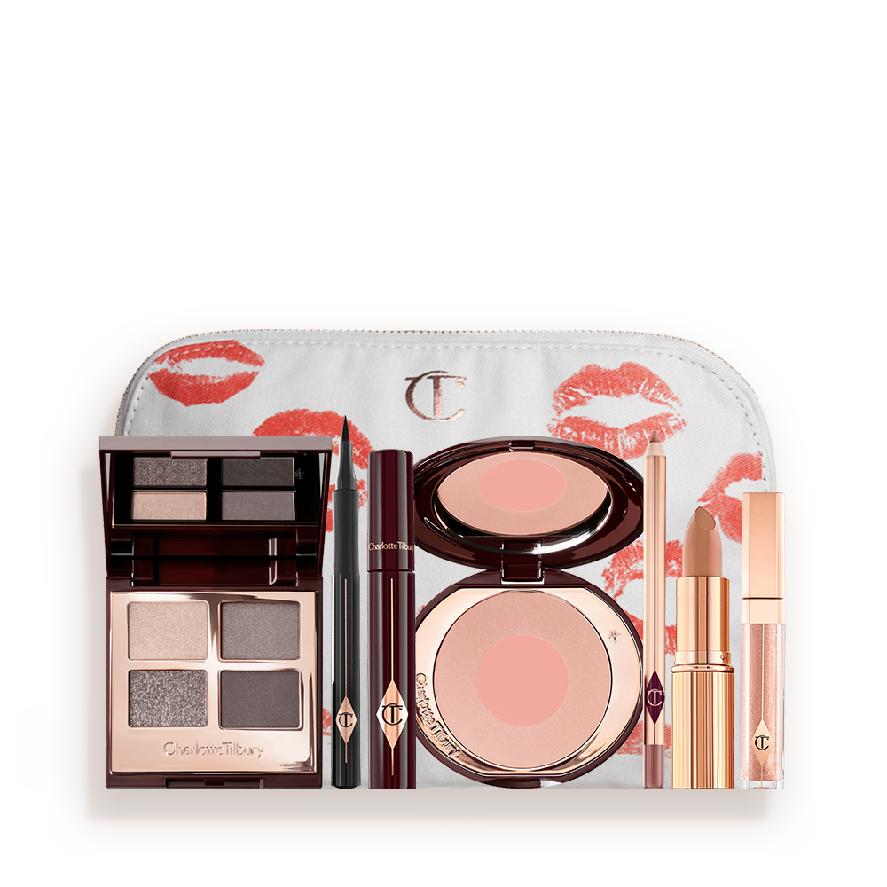 A makeup pouch with an open, mirrored-lid eyeshadow palette in matte and shimmery silver, grey, and beige shades, an open black eyeliner pen, a mascara in a dark-crimson colour scheme, a nude-pink lipstick with a matching lip liner pencil, nude pink lip gloss, and an open two-tone blush in muted rose-gold and pink. 
