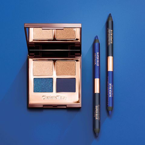 An open, mirrored-lid quad eyeshadow palette with shimmery and matte eyeshadows in shades of blue and gold, and double-sided, identical eyeliners in emerald blue and teal. 