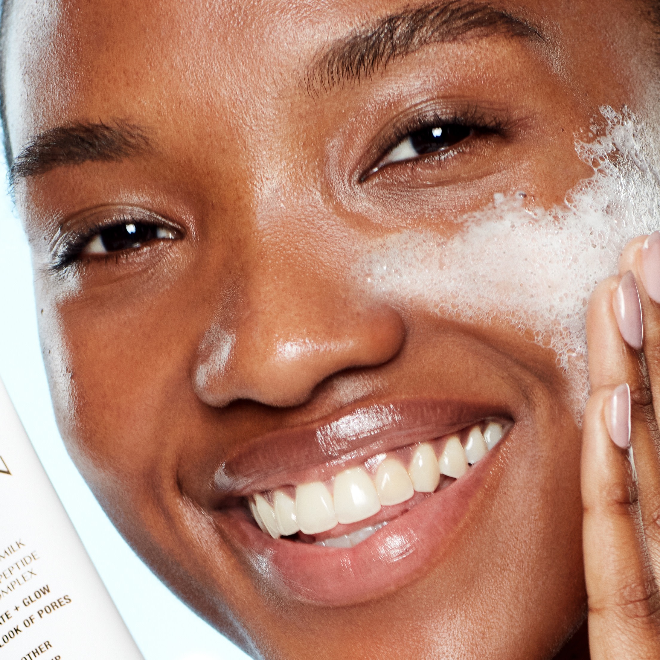 Model applying cleanser to oily skin