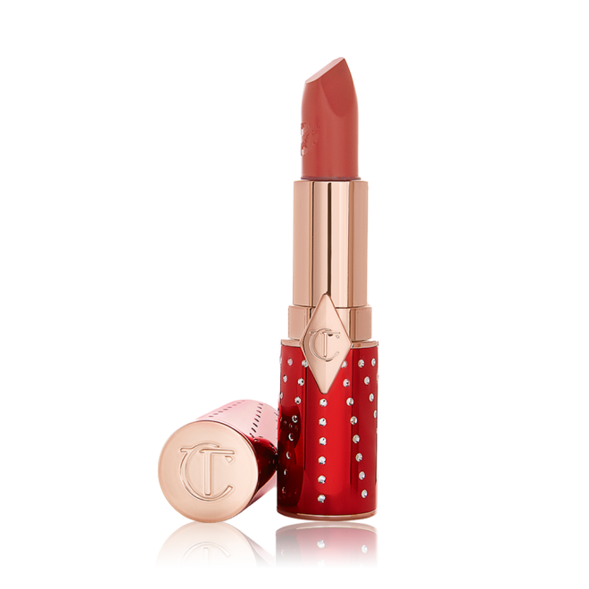 An open lipstick in a rusty rose-coloured shade with a satin-finish in a red and gold-coloured tube.