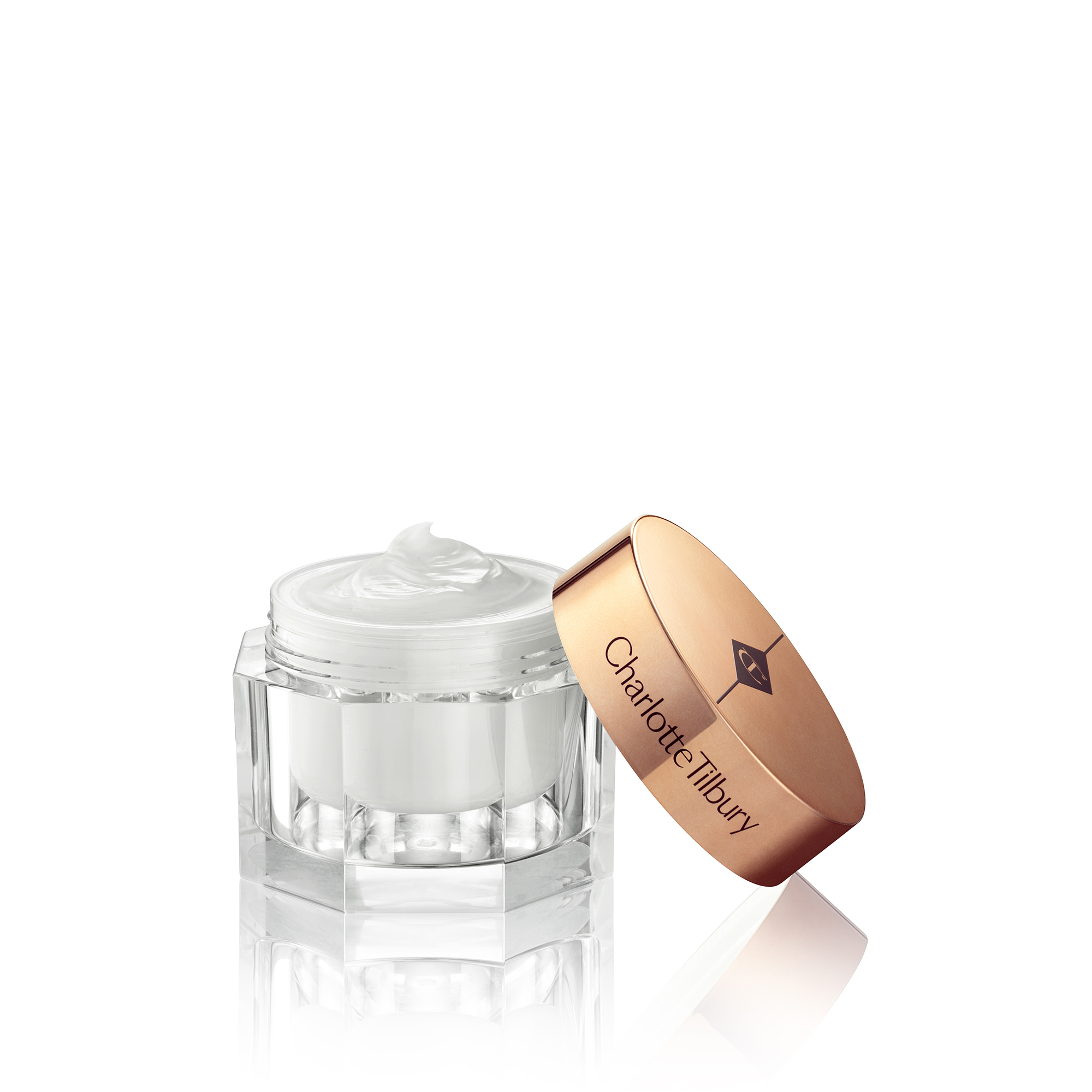 Thick and luscious pearly-white moisturiser in an open glass jar with its gold-coloured lid placed behind it. 