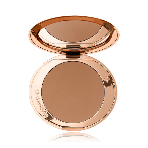 An open mirrored-lid bronzer compact in a medium-brown shade. 