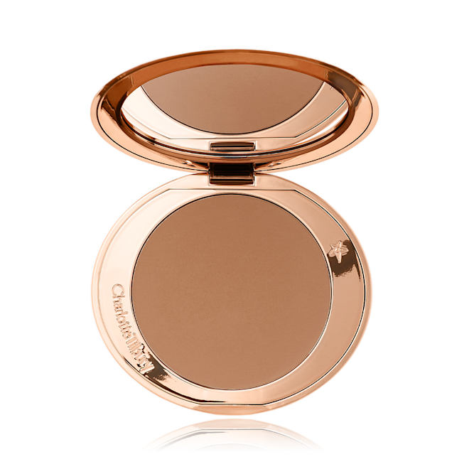 An open mirrored-lid bronzer compact in a medium-brown shade. 