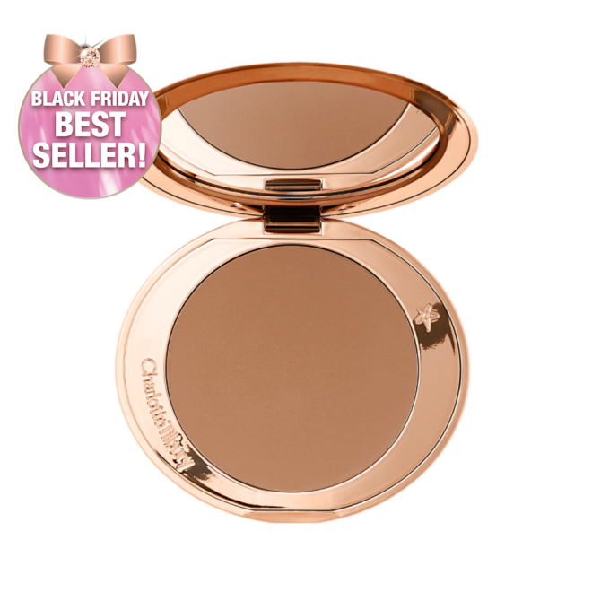 An open mirrored-lid bronzer compact in a medium-brown shade. 