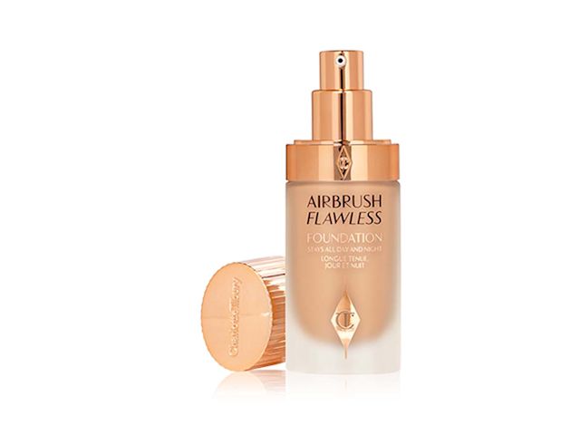 Light-coloured foundation in a frosted glass bottle with a gold-coloured pump dispenser and its lid next to it.