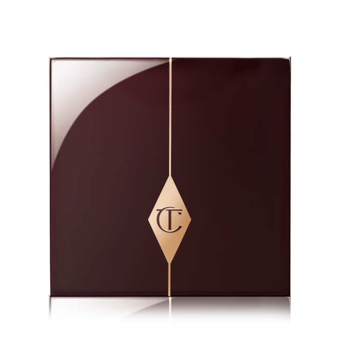 A closed eyeshadow palette with dark crimson packaging with the CT logo printed in the middle in a gold-colour.