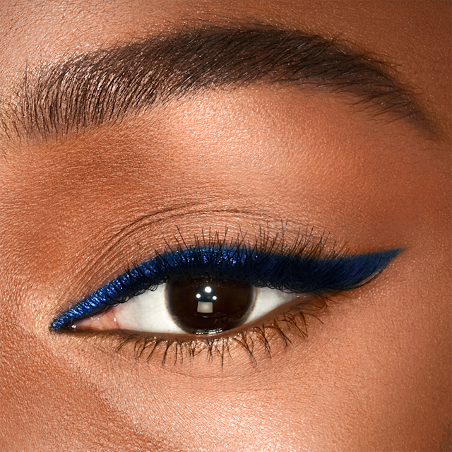 Model wearing colourful winged eyeliner using Eye Colour Magic Liner Duo in Super Blue
