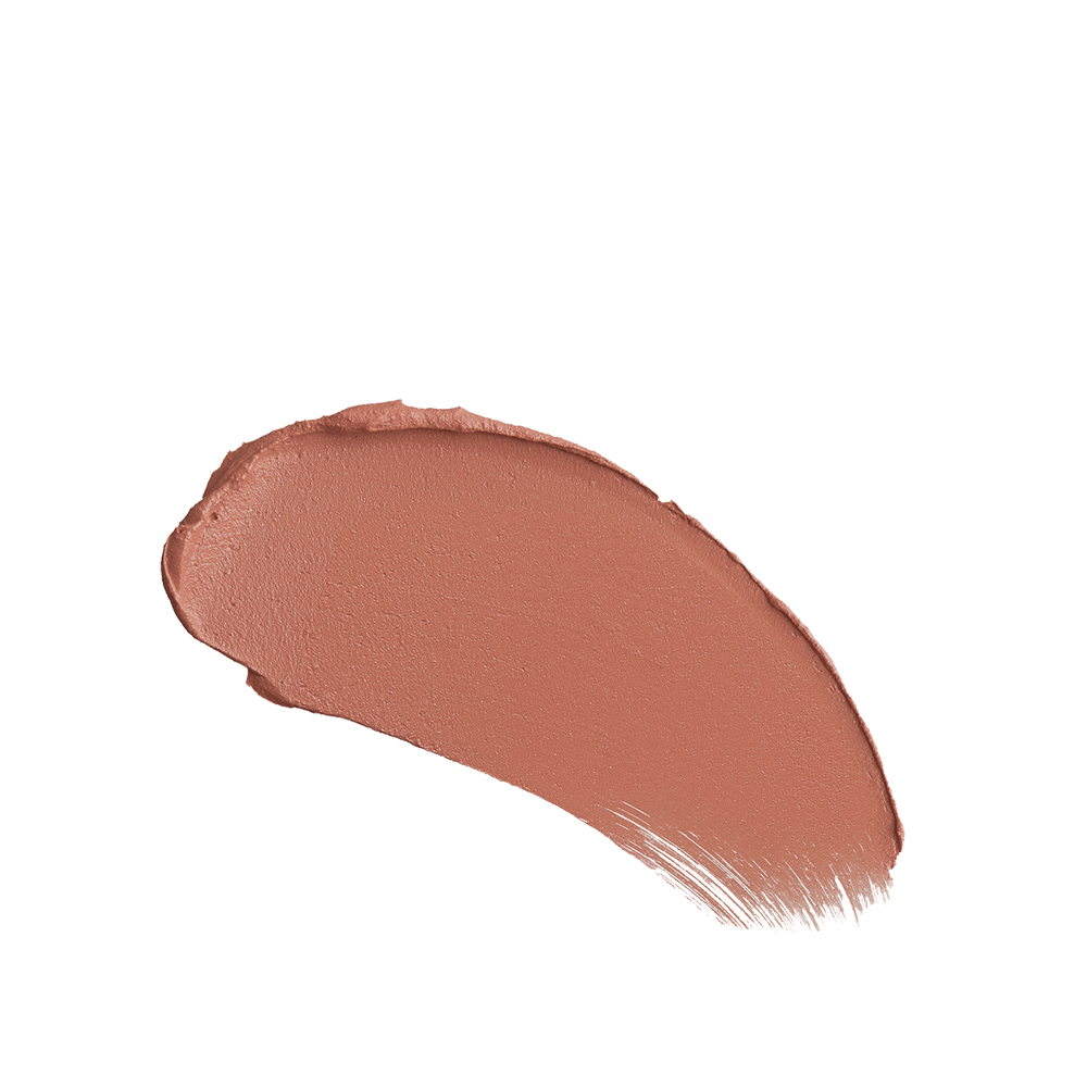 Close-up swatch of a warm, peachy-nude matte lipstick. 