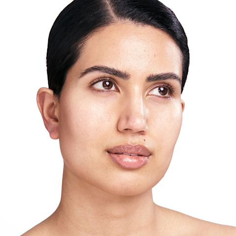 Modelo morena de tono de piel claro con una piel luminosa, hidratada y visiblemente rellena