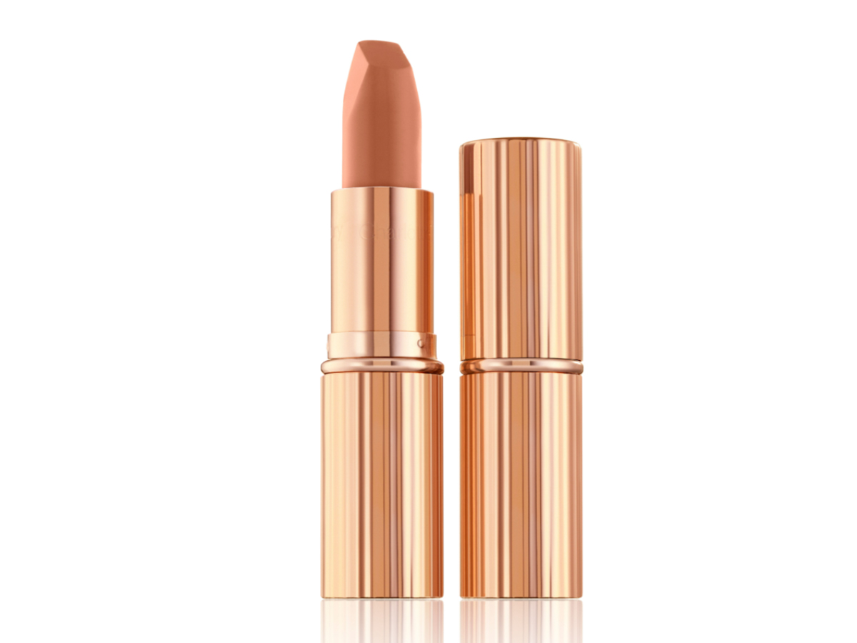 Two lipsticks, with and without lid, in a fresh, neutral nude peach matte shade, in sleek, gold-coloured tubes. 