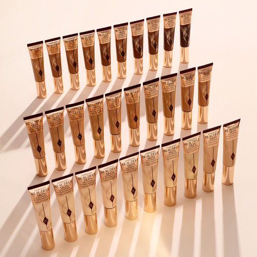 Collection of closed foundation tubes in clear bottles that shows the colour of the foundations inside along with sleek, gold-coloured lids.