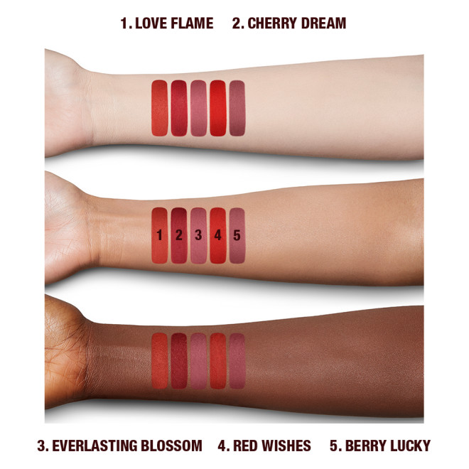 Arm swatches of 5, universally-flattering red-toned lipsticks with a matte finish in shades called, 'Love flame, cherry dream, everlasting blossom, red wishes, and berry lucky'.