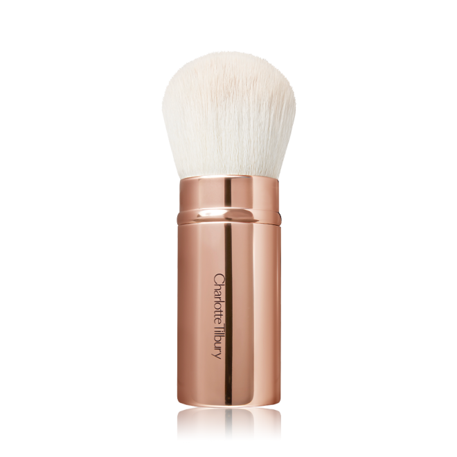 A face blending brush with white bristles in rose gold packaging.