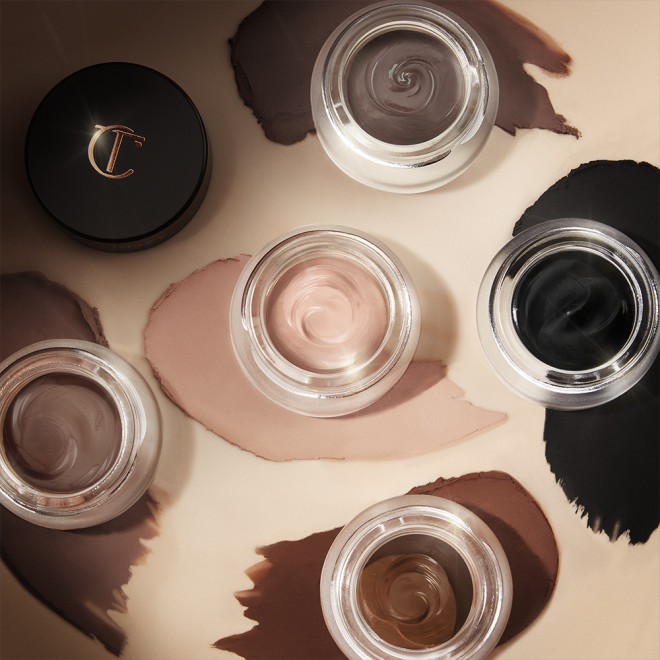 Five, glass pots with lids removed containing five cream eyeshadows with a matte finish in soft cashmere, light grey-brown, chocolate brown, smokey taupe, and jet black.