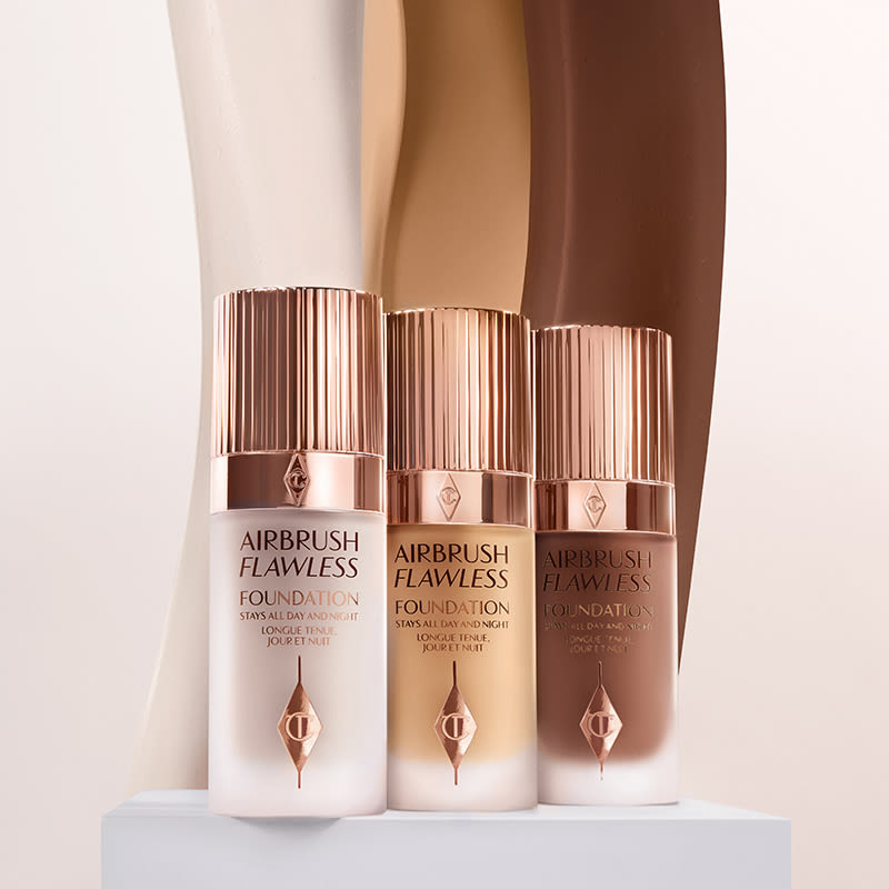 Three foundations in fair, medium, and dark shades in frosted glass bottles with gold-coloured lids. 