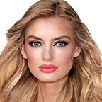 A fair-tone model with blue eyes wearing shimmery rose gold and brown eye makeup with brown eyeliner, soft pink blush, and magenta lipstick with gloss on top. 