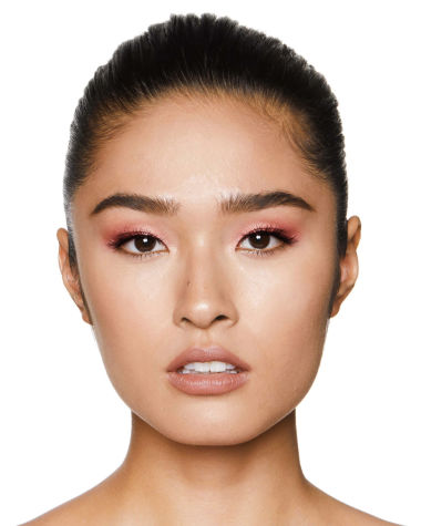 Fair-tone model with brown eyes wearing shimmery berry-pink eyeshadow with nude peach lipstick. 