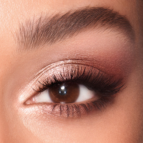 Eye close-up of a medium skin model with brown eyes wearing shimmery rose gold and champagne eyeshadow. 