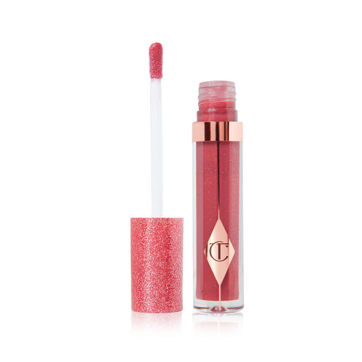 An open, berry-pink lip gloss in a glass tube with its shimmery, strawberry-red lid placed next to it.