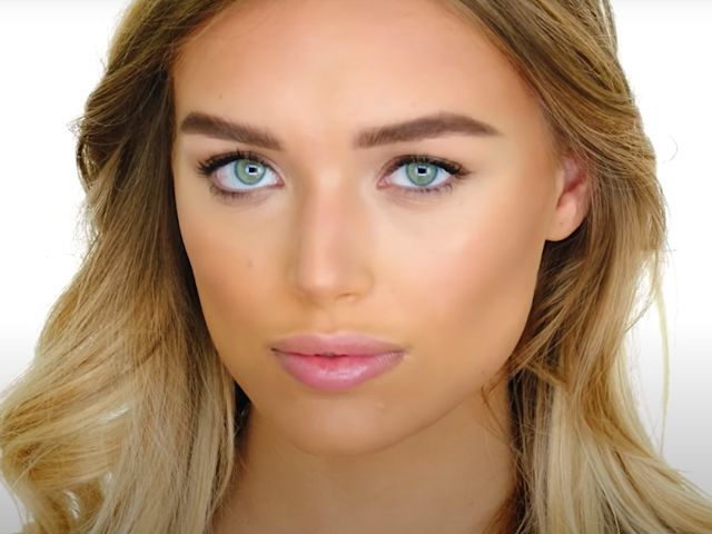 A medium-tone model with green eyes with glowy, bronzed face. 
