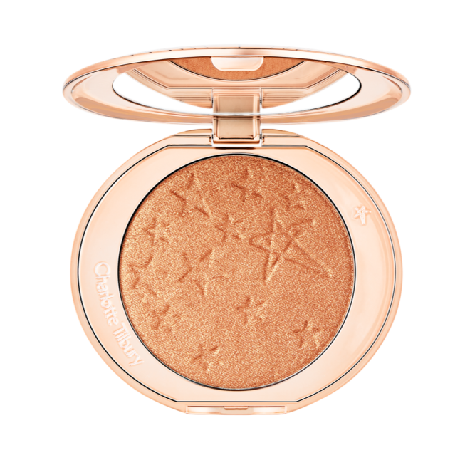 An open highlighter powder compact in a soft rose gold shade with a mirrored lid.