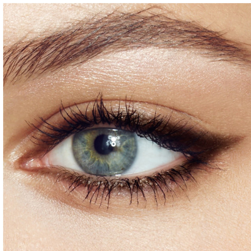 Single-eye close-up of a model with blue eyes wearing a smudged black eyeliner look. 