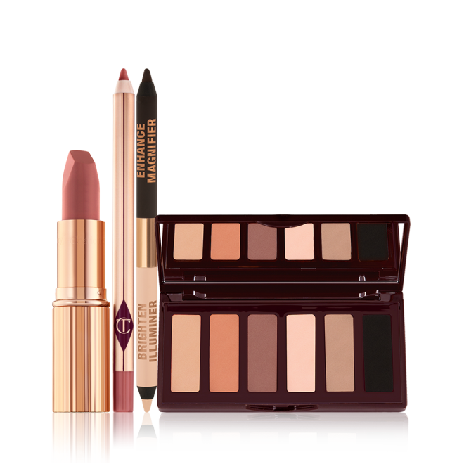 An open matte lipstick in a gold-coloured tube, lip liner pencil, double-ended eyeliner pencil in black and nude beige shades, and an open, mirrored-lid six-pan eyeshadow palette with matte eyeshadows in brown, peach, and beige shades.