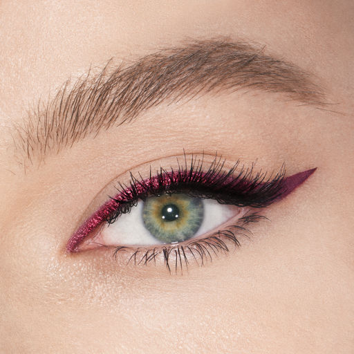 Fair-tone model with green eyes eye close-up of a sparkly maroon eyeliner with a soft wing in matte purple colour. 