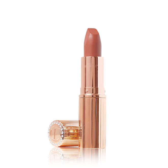 Matte Revolution in Super You lid off An open matte lipstick in a warm, peachy-nude shade with its lid next to it.