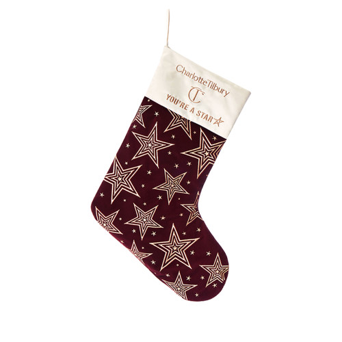 A maroon-coloured holiday stocking with gold-coloured stars printed all over. 