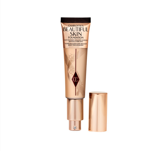 An open foundation wand in gold packaging with a pump dispenser and a light-brown-coloured body to show the shade of the foundation inside. 