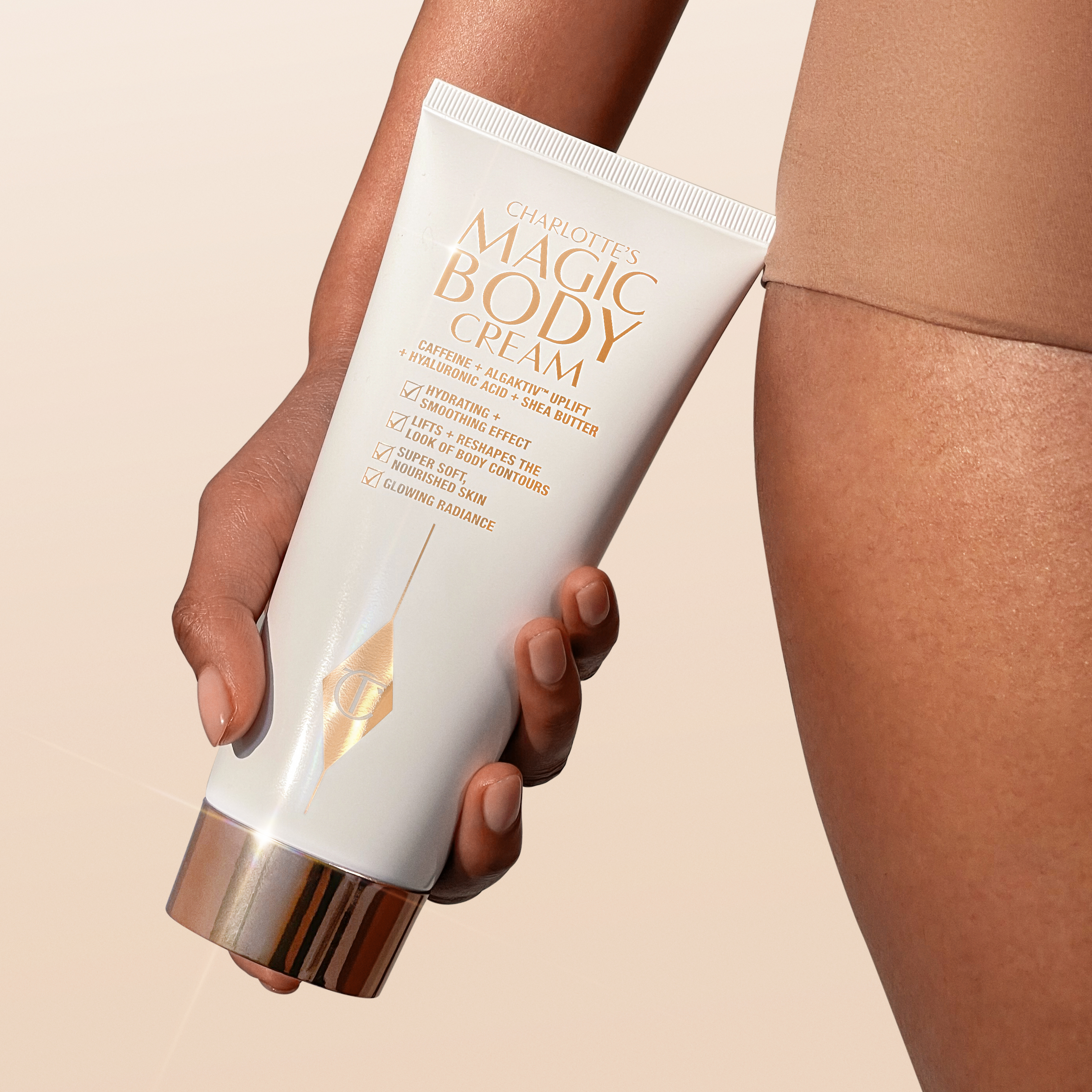 Model holding Charlotte's Magic Body Cream for smoother, firmer-looking skin