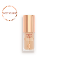 A closed glow-boosting primer in a glass bottle with a rose gold-coloured lid. 