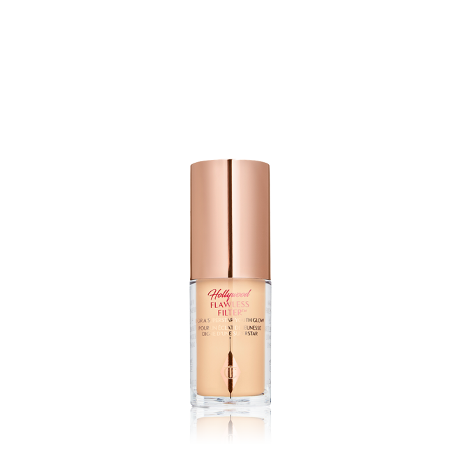 A closed glow-boosting primer in a glass bottle with a rose gold-coloured lid. 