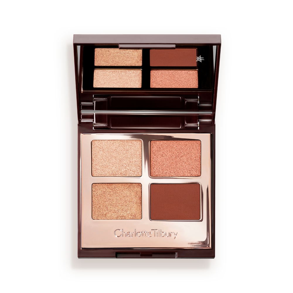 Una paleta de sombras de ojos de cuatro tonos, abierta y con tapa de espejo, con sombras mates y brillantes en granate, marrón oscuro, champán y oro rosa. 