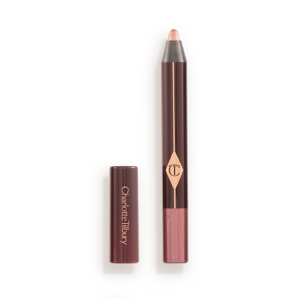 An open chubby eyeshadow stick in pink with rose gold sparkle with its lid next to it.