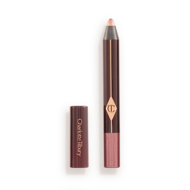 An open chubby eyeshadow stick in pink with rose gold sparkle with its lid next to it.
