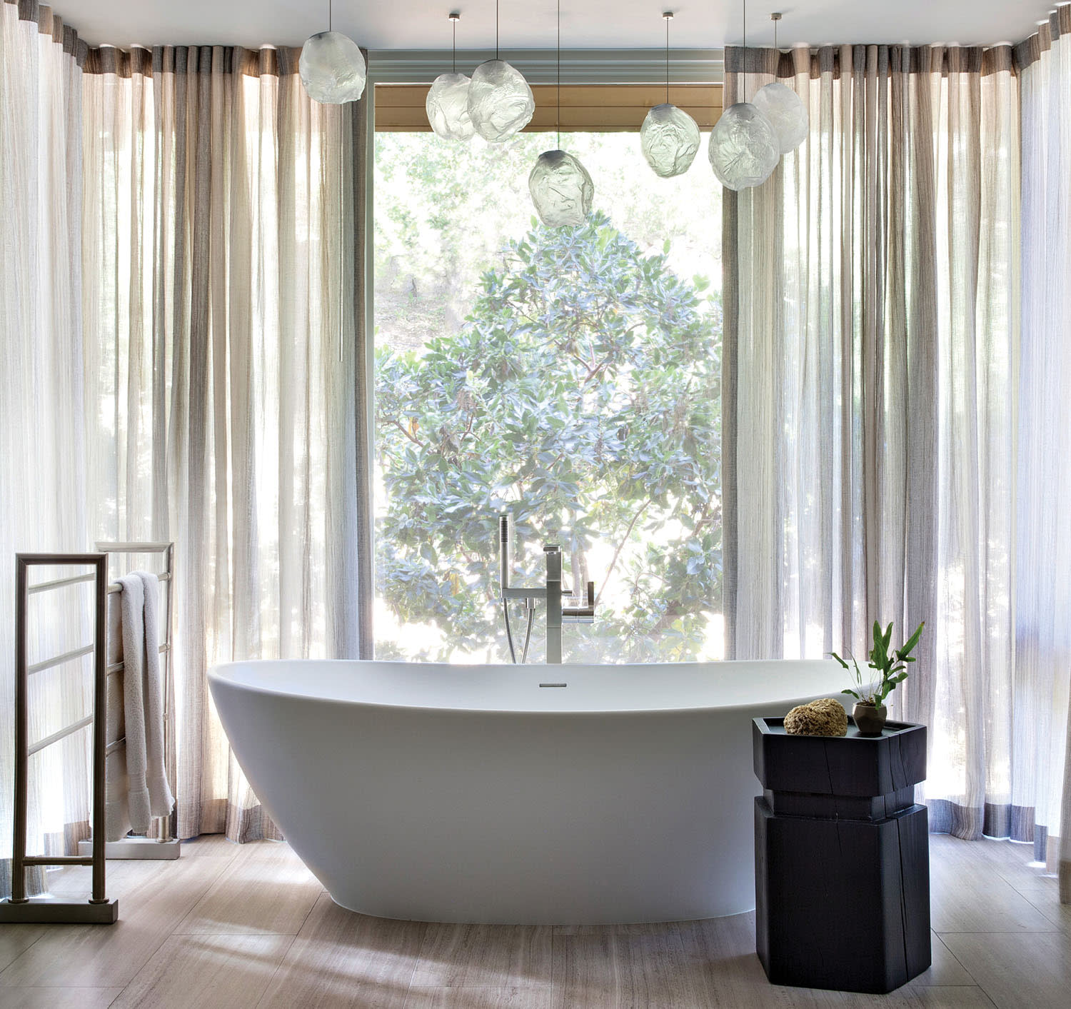 Bocci pendants float above a tub in a contemporary bathroom