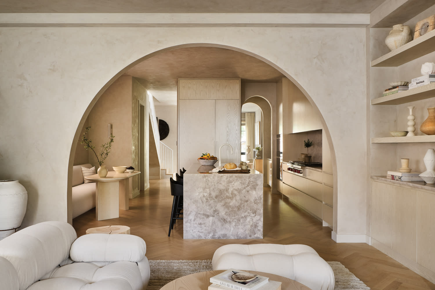 Archway leads into a kitchen with a honed white-crystal quartzite island and a breakfast nook