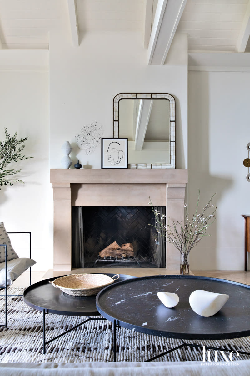 A stone fireplace mantel is the focal point of a living room.