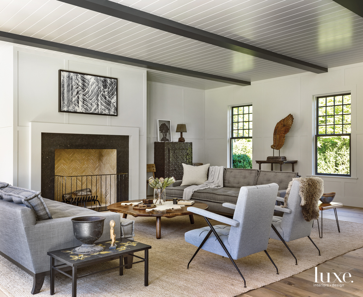 living room with contrasting black beams and white walls accented by organic-inspired furniture