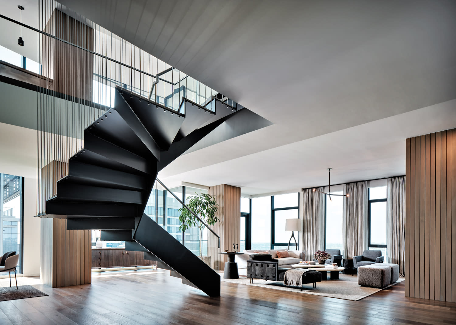 high-rise living room with architectural staircase in home by Brooke Wilbratte